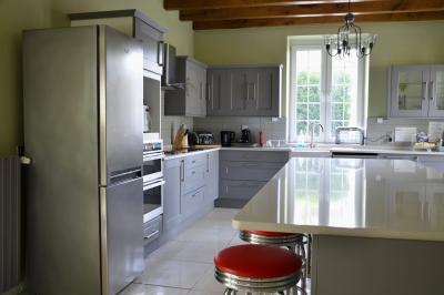 Deux femmes souriantes posent devant une voiture grise marquée ’France Bleu’, stationnée devant un bâtiment en pierre.