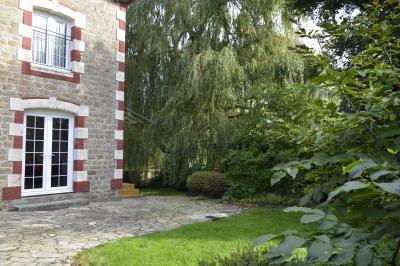 Deux femmes souriantes posent devant une voiture grise marquée ’France Bleu’, stationnée devant un bâtiment en pierre.