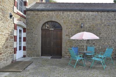 Deux femmes souriantes posent devant une voiture grise marquée ’France Bleu’, stationnée devant un bâtiment en pierre.