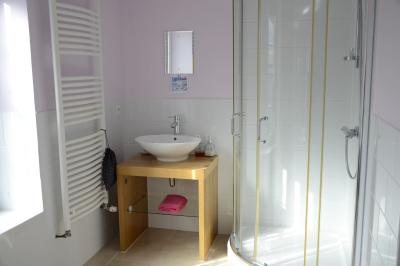 Deux femmes souriantes posent devant une voiture grise marquée ’France Bleu’, stationnée devant un bâtiment en pierre.