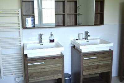 Deux femmes souriantes posent devant une voiture grise marquée ’France Bleu’, stationnée devant un bâtiment en pierre.