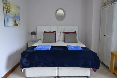 Deux femmes souriantes posent devant une voiture grise marquée ’France Bleu’, stationnée devant un bâtiment en pierre.