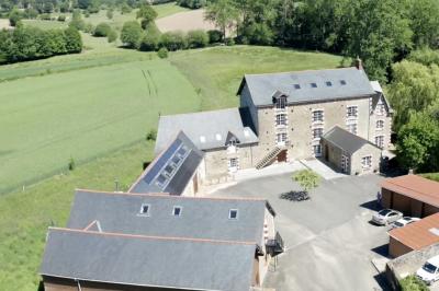 Deux femmes souriantes posent devant une voiture grise marquée ’France Bleu’, stationnée devant un bâtiment en pierre.