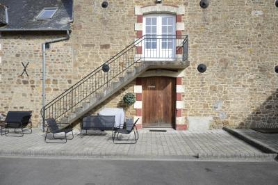 Deux femmes souriantes posent devant une voiture grise marquée ’France Bleu’, stationnée devant un bâtiment en pierre.