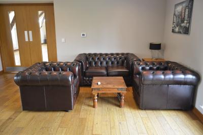 Deux femmes souriantes posent devant une voiture grise marquée ’France Bleu’, stationnée devant un bâtiment en pierre.