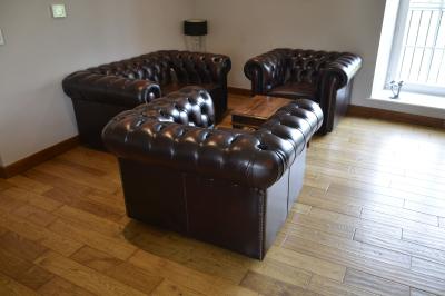 Deux femmes souriantes posent devant une voiture grise marquée ’France Bleu’, stationnée devant un bâtiment en pierre.