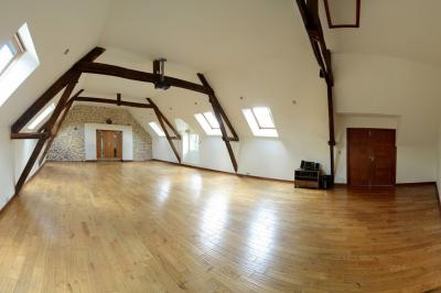 Deux femmes souriantes posent devant une voiture grise marquée ’France Bleu’, stationnée devant un bâtiment en pierre.