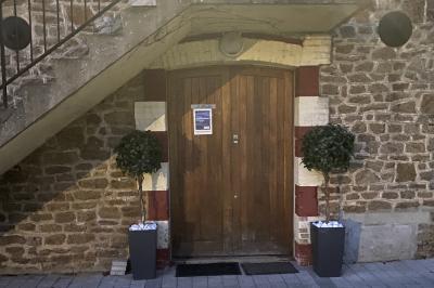 Deux femmes souriantes posent devant une voiture grise marquée ’France Bleu’, stationnée devant un bâtiment en pierre.
