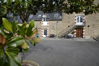 Deux femmes souriantes posent devant une voiture grise marquée ’France Bleu’, stationnée devant un bâtiment en pierre.
