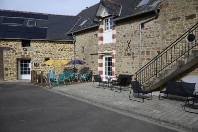 Deux femmes souriantes posent devant une voiture grise marquée ’France Bleu’, stationnée devant un bâtiment en pierre.