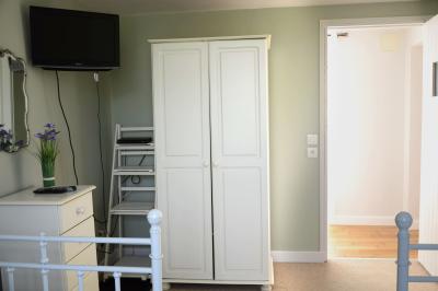 Deux femmes souriantes posent devant une voiture grise marquée ’France Bleu’, stationnée devant un bâtiment en pierre.