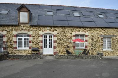 Deux femmes souriantes posent devant une voiture grise marquée ’France Bleu’, stationnée devant un bâtiment en pierre.