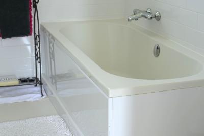 Deux femmes souriantes posent devant une voiture grise marquée ’France Bleu’, stationnée devant un bâtiment en pierre.