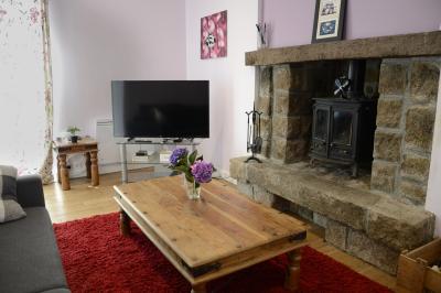 Deux femmes souriantes posent devant une voiture grise marquée ’France Bleu’, stationnée devant un bâtiment en pierre.