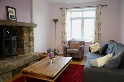 Deux femmes souriantes posent devant une voiture grise marquée ’France Bleu’, stationnée devant un bâtiment en pierre.