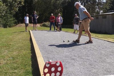 Deux femmes souriantes posent devant une voiture grise marquée ’France Bleu’, stationnée devant un bâtiment en pierre.