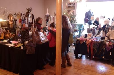 Deux femmes souriantes posent devant une voiture grise marquée ’France Bleu’, stationnée devant un bâtiment en pierre.