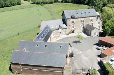 Deux femmes souriantes posent devant une voiture grise marquée ’France Bleu’, stationnée devant un bâtiment en pierre.