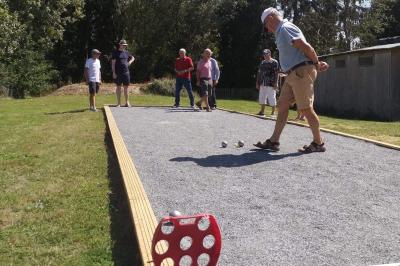 Deux femmes souriantes posent devant une voiture grise marquée ’France Bleu’, stationnée devant un bâtiment en pierre.