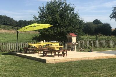 Deux femmes souriantes posent devant une voiture grise marquée ’France Bleu’, stationnée devant un bâtiment en pierre.