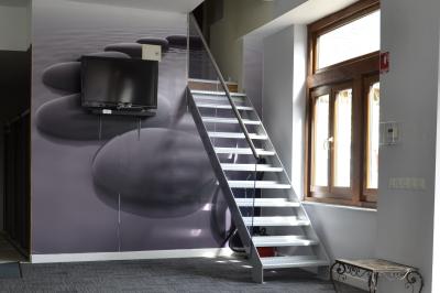 Deux femmes souriantes posent devant une voiture grise marquée ’France Bleu’, stationnée devant un bâtiment en pierre.