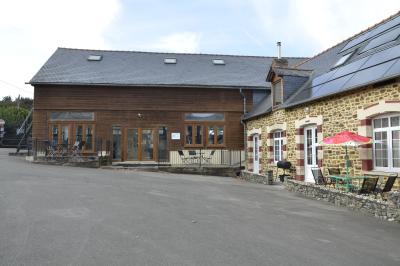 Deux femmes souriantes posent devant une voiture grise marquée ’France Bleu’, stationnée devant un bâtiment en pierre.