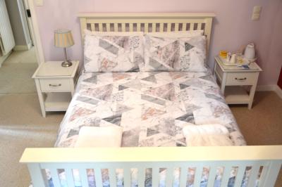 Deux femmes souriantes posent devant une voiture grise marquée ’France Bleu’, stationnée devant un bâtiment en pierre.