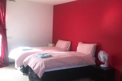 Deux femmes souriantes posent devant une voiture grise marquée ’France Bleu’, stationnée devant un bâtiment en pierre.