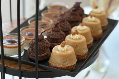 Gâteau de fête décoré de bougies scintillantes, entouré de desserts et de convives en arrière-plan flou.