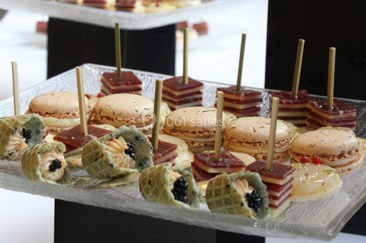 Assortiment de bouchées apéritives comprenant macarons salés, gelées sur piques et cônes garnis de crème et caviar.