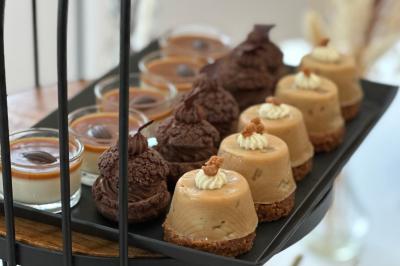 Gâteau de fête décoré de bougies scintillantes, entouré de desserts et de convives en arrière-plan flou.