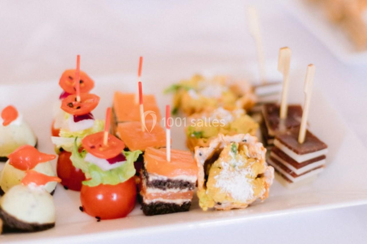 Assortiment de bouchées apéritives variées présentées sur un plateau blanc.
