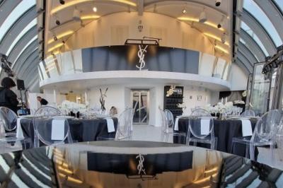 Vue d'une terrasse urbaine et d'un espace intérieur vitré avec parquet, offrant une perspective sur des bâtiments parisiens.