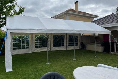 Guirlandes lumineuses suspendues sous une tente blanche avec une toile translucide.