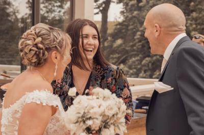 Façade d'une maison ancienne avec volets bleus, entourée de végétation et éclairée par des guirlandes lumineuses.