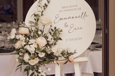 Façade d'une maison ancienne avec volets bleus, entourée de végétation et éclairée par des guirlandes lumineuses.