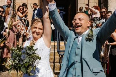 Façade d'une maison ancienne avec volets bleus, entourée de végétation et éclairée par des guirlandes lumineuses.