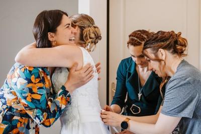 Façade d'une maison ancienne avec volets bleus, entourée de végétation et éclairée par des guirlandes lumineuses.