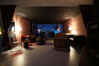 Cour intérieure avec sol en bois, quatre tonneaux et deux grandes sphères blanches près d'un mur et d'une porte vitrée.