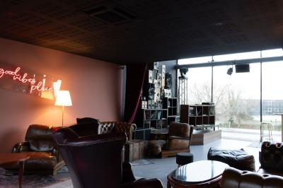 Cour intérieure avec sol en bois, quatre tonneaux et deux grandes sphères blanches près d'un mur et d'une porte vitrée.