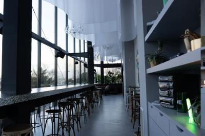 Cour intérieure avec sol en bois, quatre tonneaux et deux grandes sphères blanches près d'un mur et d'une porte vitrée.