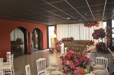 Cour intérieure avec sol en bois, quatre tonneaux et deux grandes sphères blanches près d'un mur et d'une porte vitrée.