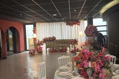 Cour intérieure avec sol en bois, quatre tonneaux et deux grandes sphères blanches près d'un mur et d'une porte vitrée.
