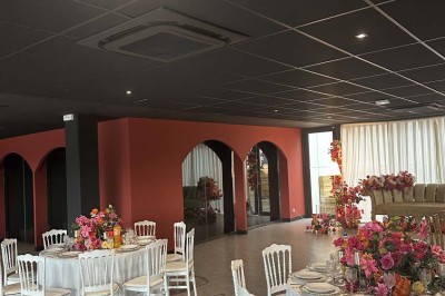 Cour intérieure avec sol en bois, quatre tonneaux et deux grandes sphères blanches près d'un mur et d'une porte vitrée.