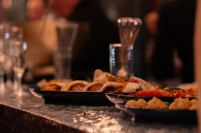 Miniature Location salle Bruges (Gironde) - Vango #18 Verres vides et flûtes à champagne sur un comptoir de bar, avec des clients flous en arrière-plan.