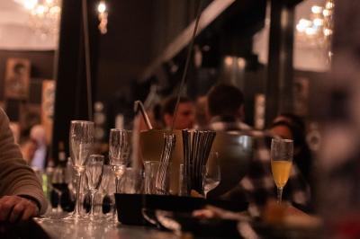 Miniature Location salle Bruges (Gironde) - Vango #20 Verres vides et flûtes à champagne sur un comptoir de bar, avec des clients flous en arrière-plan.