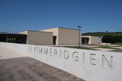 Cuisine professionnelle avec plans de travail en inox sur roulettes, four industriel et carrelage au sol.