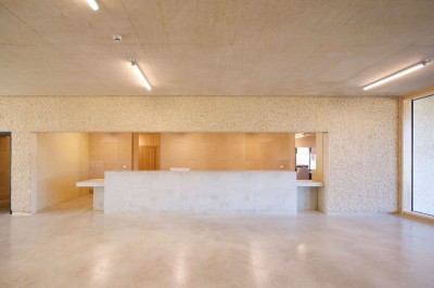 Cuisine professionnelle avec plans de travail en inox sur roulettes, four industriel et carrelage au sol.