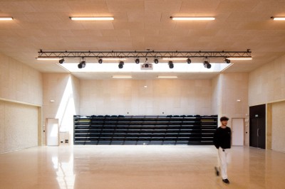 Cuisine professionnelle avec plans de travail en inox sur roulettes, four industriel et carrelage au sol.