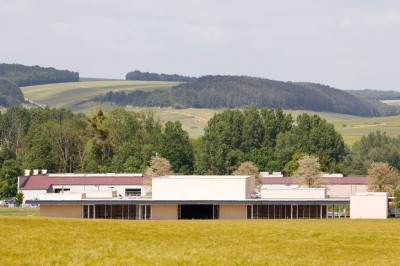 Miniature Location salle Chablis (Yonne) - Le Kimmeridgien #10 Un comptoir en béton dans un espace intérieur minimaliste avec sol en béton, murs texturés et grande porte vitrée.